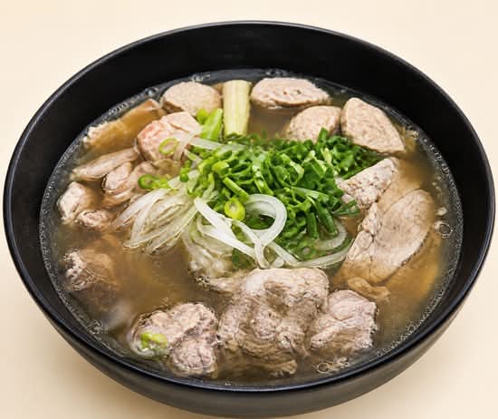 Beef phở with rice noodles, sliced beef and fresh chives
