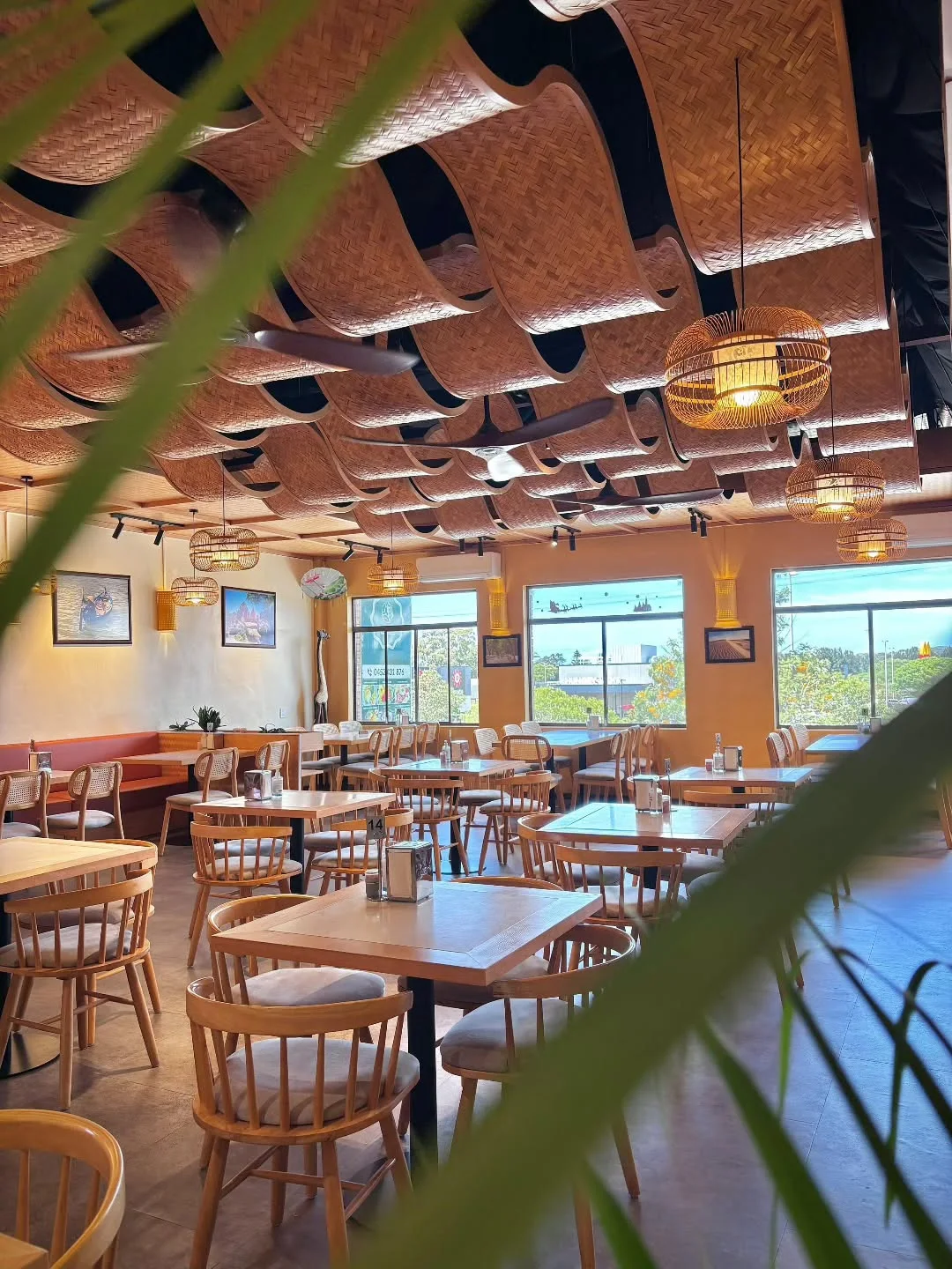 Special Dish's sunlit dining room with woven ceiling panels, glowing lanterns and timber tables