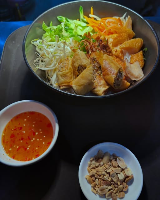 Grilled pork and spring roll vermicelli with pickles, peanuts and dipping sauce